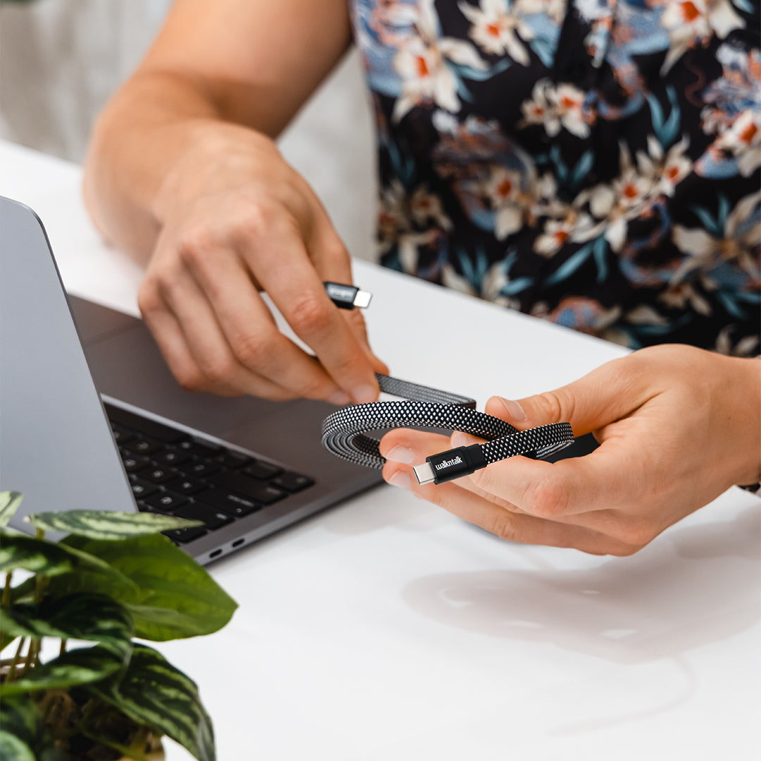 Man folding up a USB C Magnetic Cable near his laptop