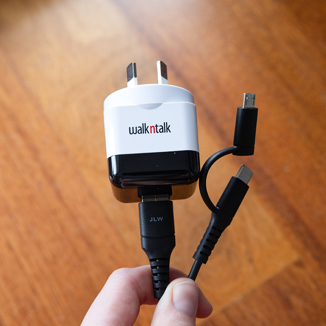 Someone holding a Wall Charger & 2in1 Charge & Sync Cable combo