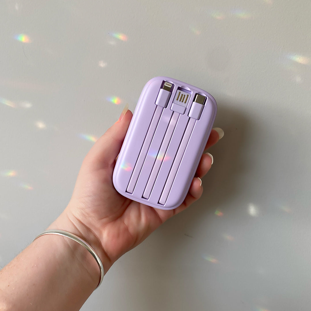 Woman holding and showing the back of the Purple 8K Travel Power Bank