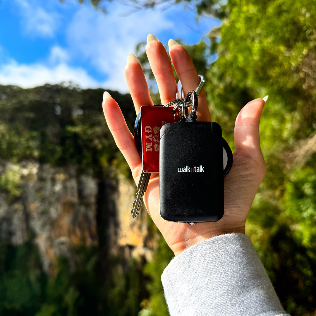 Black Emergency Mini Power Bank Keychain on a car keychain being held in a woman's hand